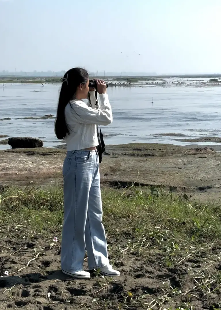 A girl birdwatching with binoculars at Maguri Beel Tinsukia Assam