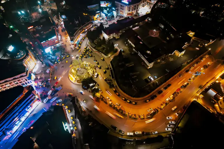 Aerial night view of the bustling Police Bazar in Meghalaya, lit with vibrant streetlights and busy traffic