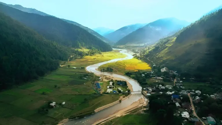Aerial view of Sangti Valley with a river winding through green fields and hills in Arunachal Pradesh