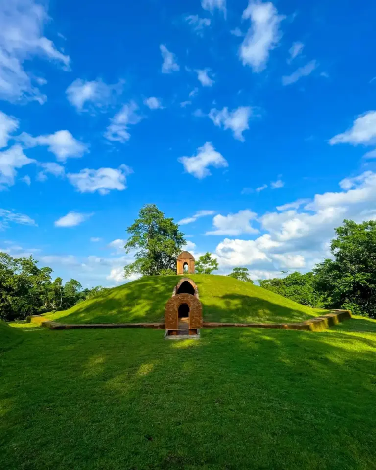 Ancient burial mound at Charaideo Maidam in Assam under a bright blue sky