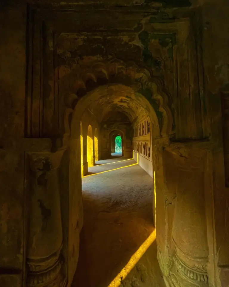 Arched corridor inside Talatal Ghar with sunlight