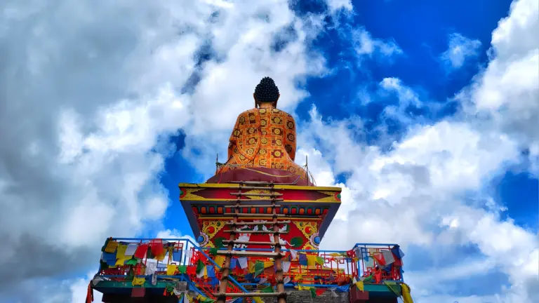 Colorful Buddhist stupa at Sangti Valley against a bright blue sky with clouds