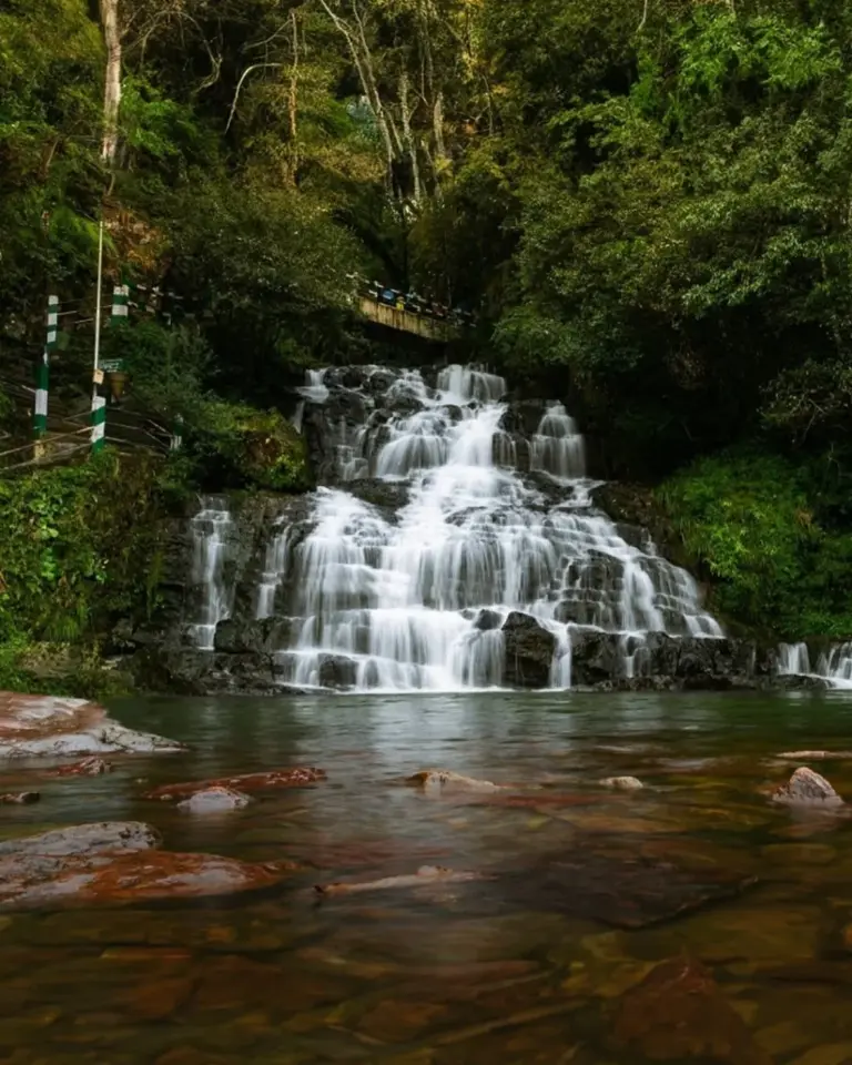 Elephant Falls cascading through forested cliffs and moss-covered rocks in Meghalaya, India