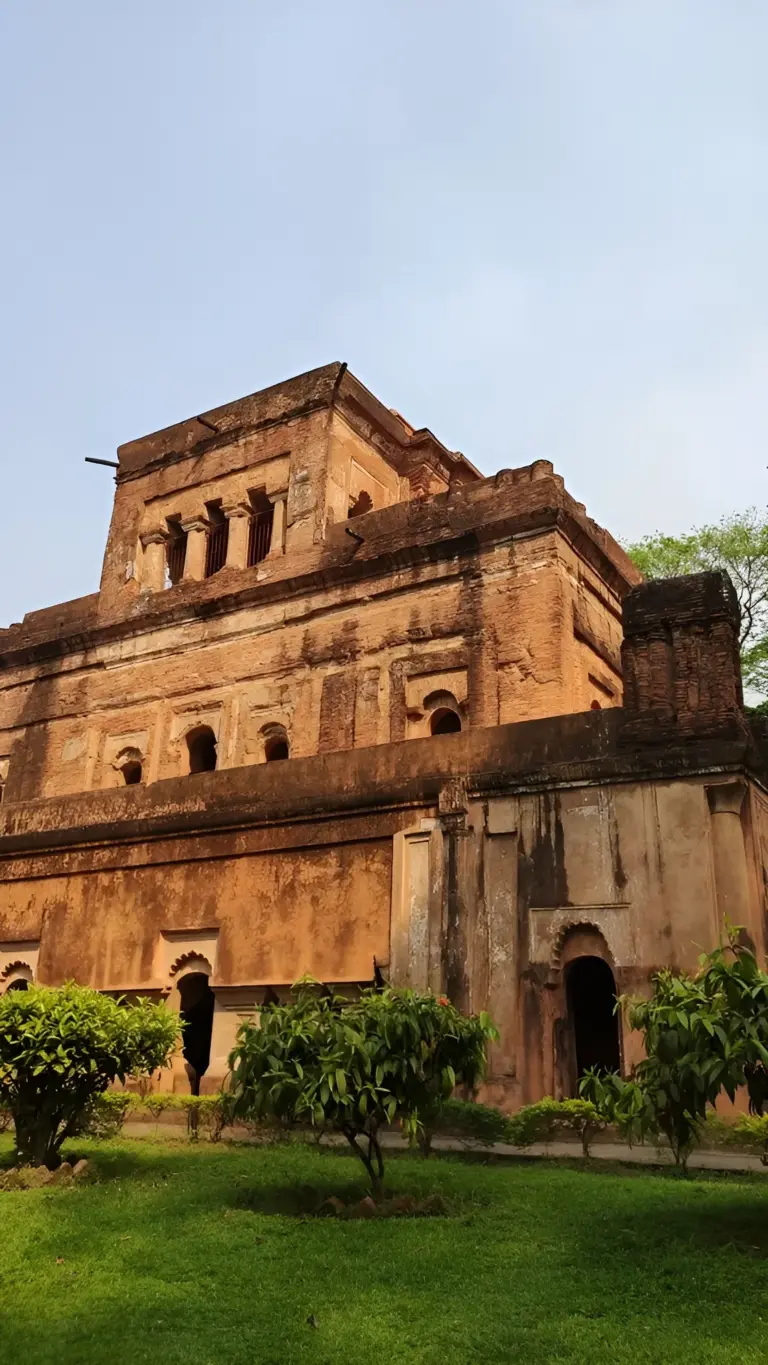 Exterior view of the historic Kareng Ghar palace in Assam, surrounded by greenery