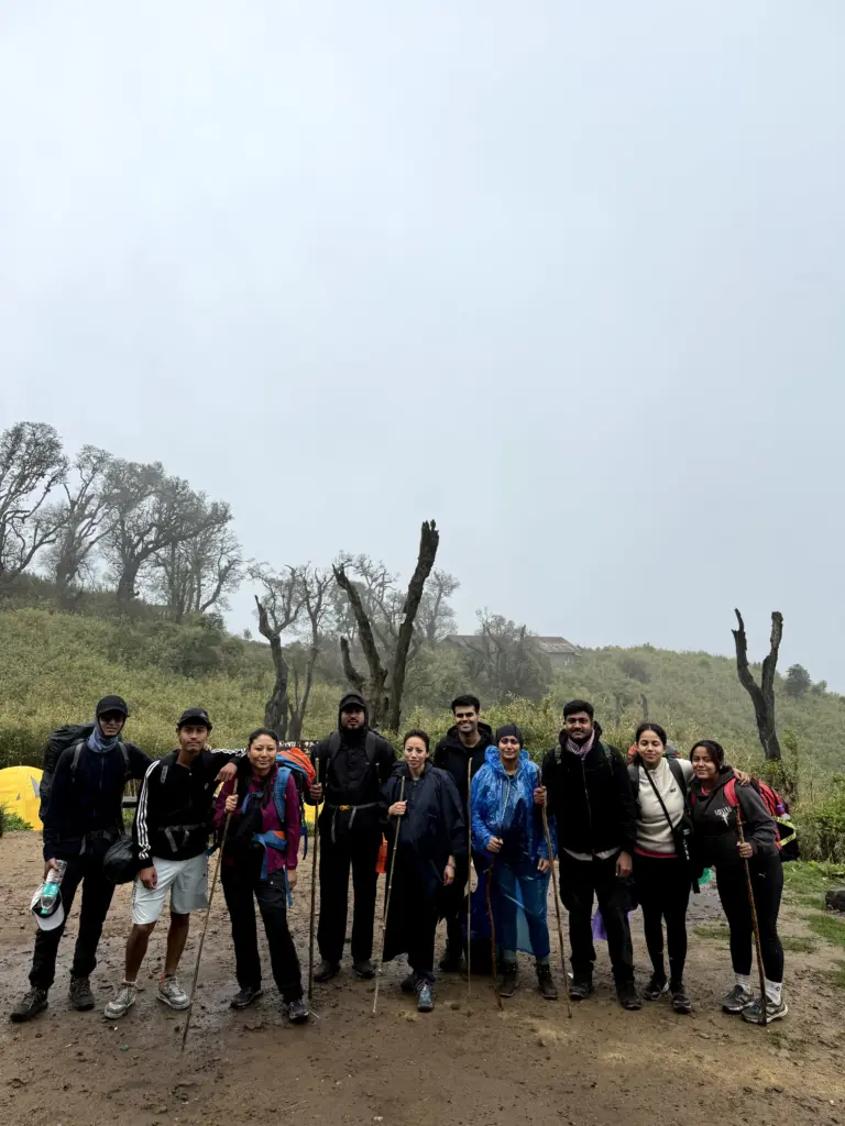 Group of people posing with walking sticks at Dzukou Valley campsite
