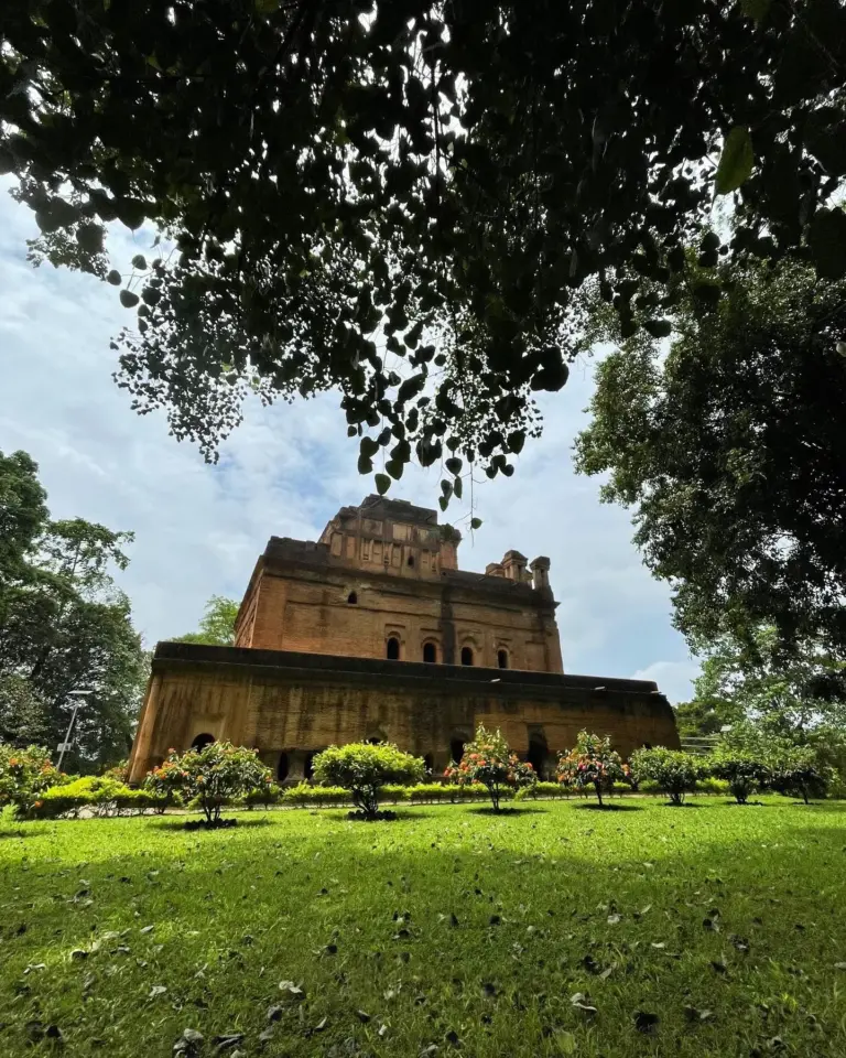 Kareng Ghar in Assam framed by lush trees and vibrant greenery