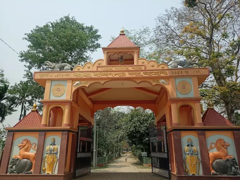 Main entrance gate of Dakhinpat Satra in Assam, adorned with vibrant sculptures and traditional motifs