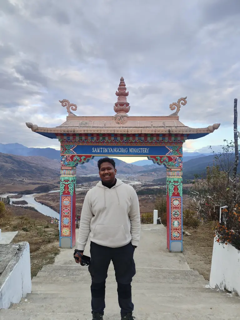Man posing at the entrance of Samten Yangchag Monastery in Mechuka, Arunachal Pradesh