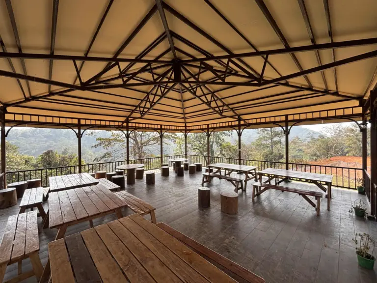 Open-air seating pavilion overlooking lush hills at a tea garden in Guwahati Assam