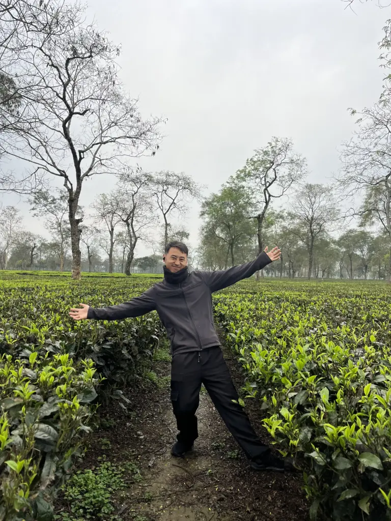 Person posing with open arms in Manohari Tea Garden Dibrugarh Assam