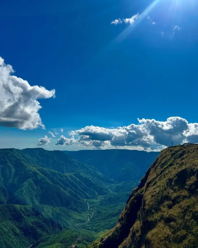 Scenic view of green valleys and hills under a bright blue sky at Laitlum, Meghalaya