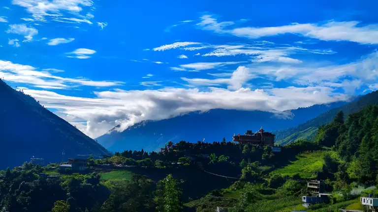 Scenic view of mountains, clouds, and a monastery at Sangti Valley