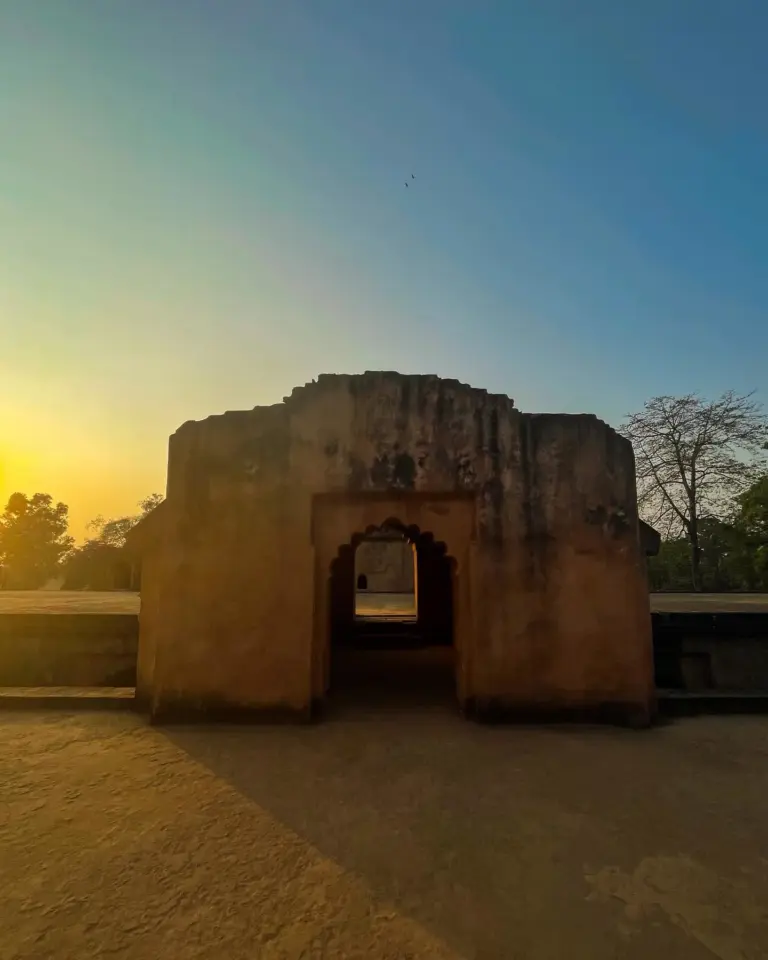 Sunset view of an arched doorway at Kareng Ghar, Assam, casting long shadows