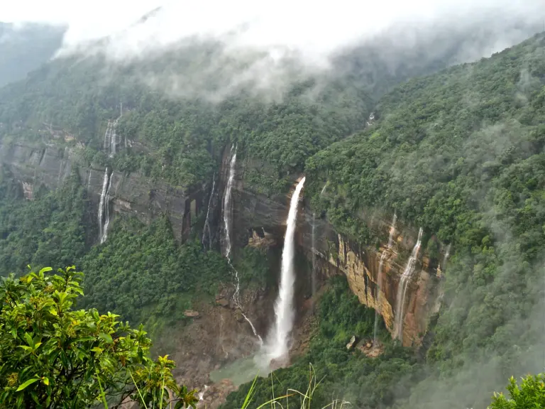 Tall waterfall cascading down lush green cliffs at Nohkalikai Falls Meghalaya