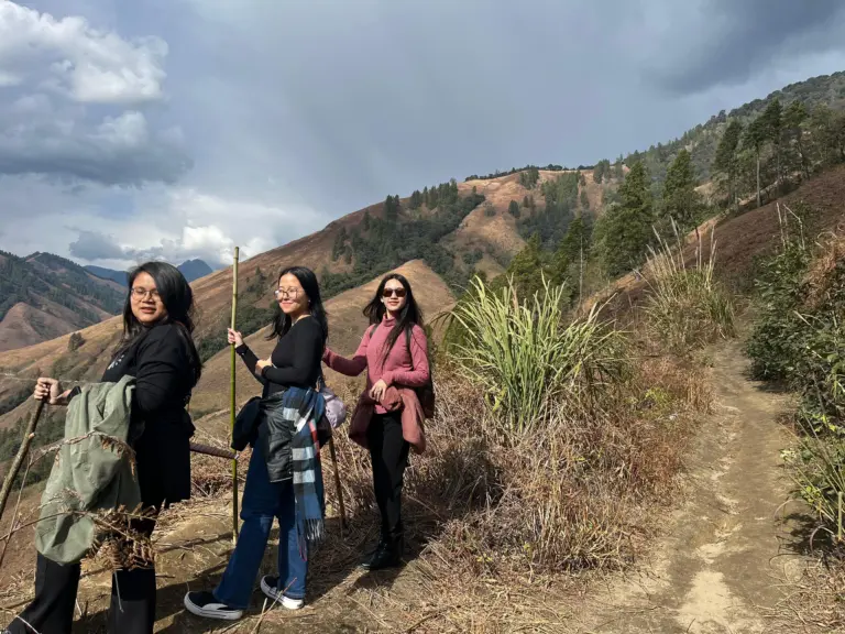 Three women hiking along a mountain trail in Anini, Arunachal Pradesh