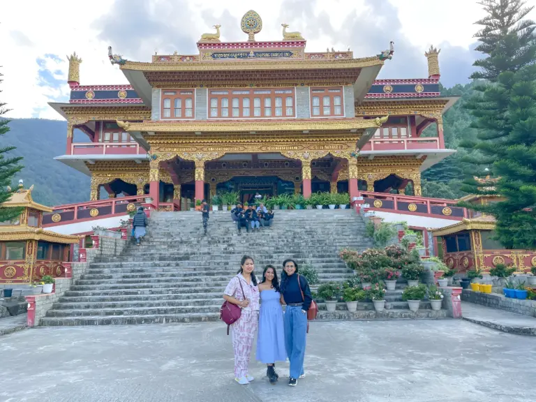Three women posing in front of Dirang Monastery, Arunachal Pradesh