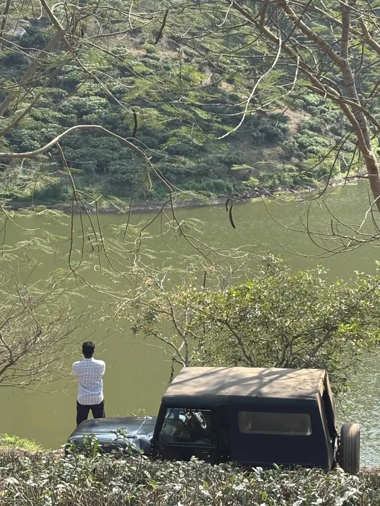 Visitor standing by a lake surrounded by tea gardens in Guwahati Assam