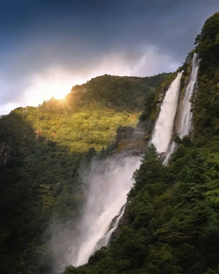 Waterfall cascading down a lush green mountainside at Nuranang Falls, Arunachal Pradesh