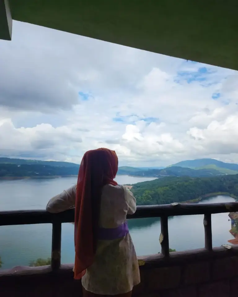 Woman enjoying the scenic view of Umiam Lake and surrounding hills in Meghalaya
