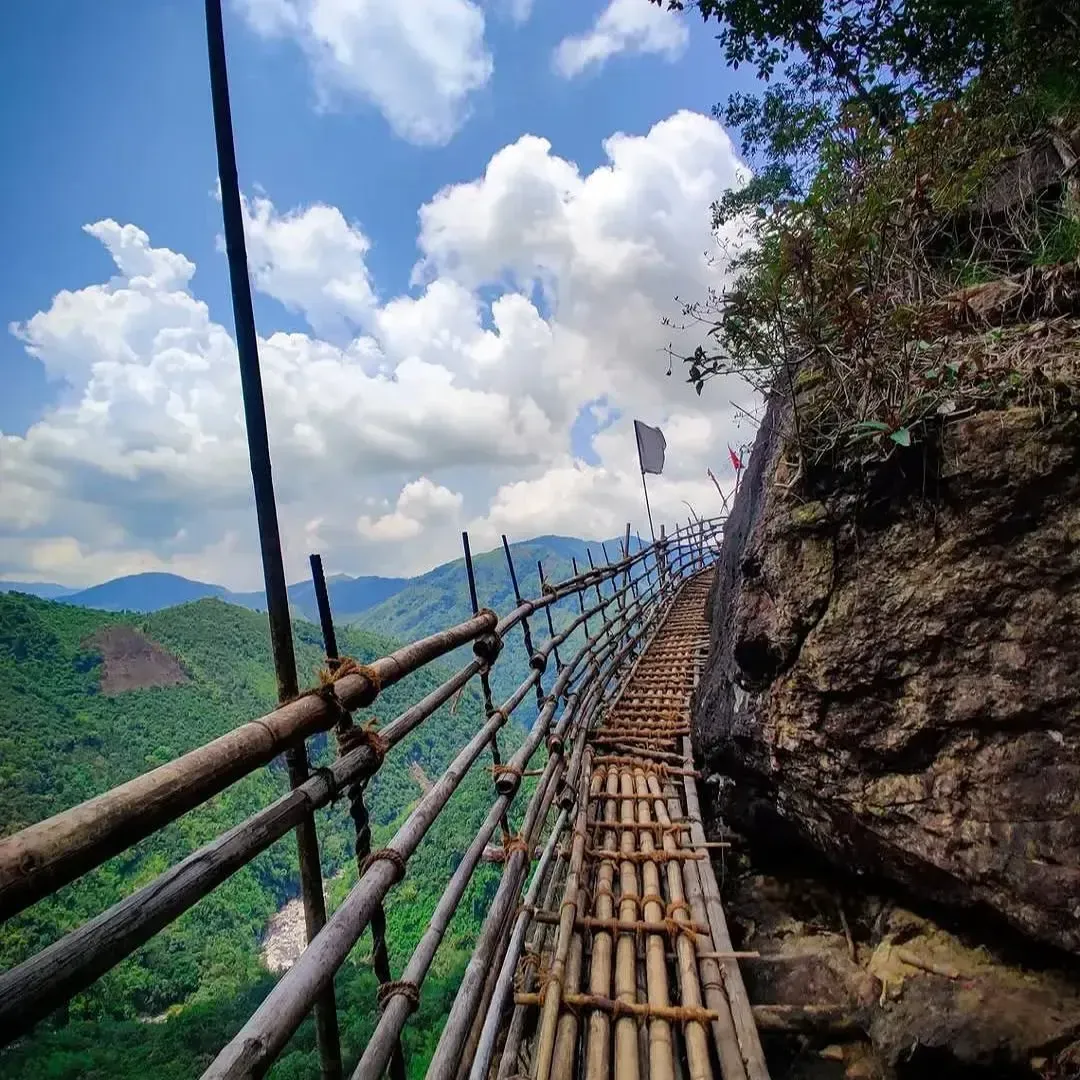 Bamboo walkway along the scenic Mawryngkhang Bamboo Trek, overlooking lush green hills and dramatic cliffs in Meghalaya