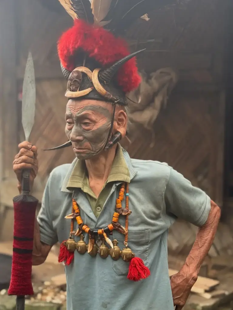 Elderly Konyak tribesman wearing a traditional feathered headdress, facial tattoos
