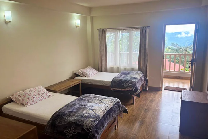 Twin bed room with balcony door at Linden Homestay