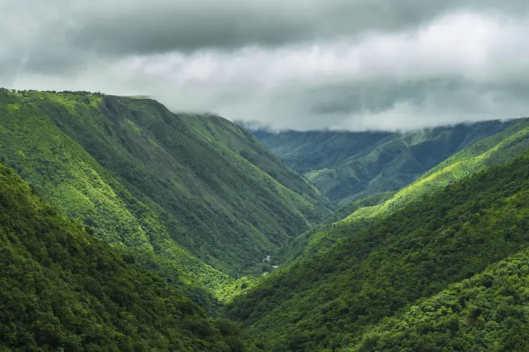 s 1 Lush green hills and deep valley under cloudy skies at Mawkdok Valley View Point, Meghalaya