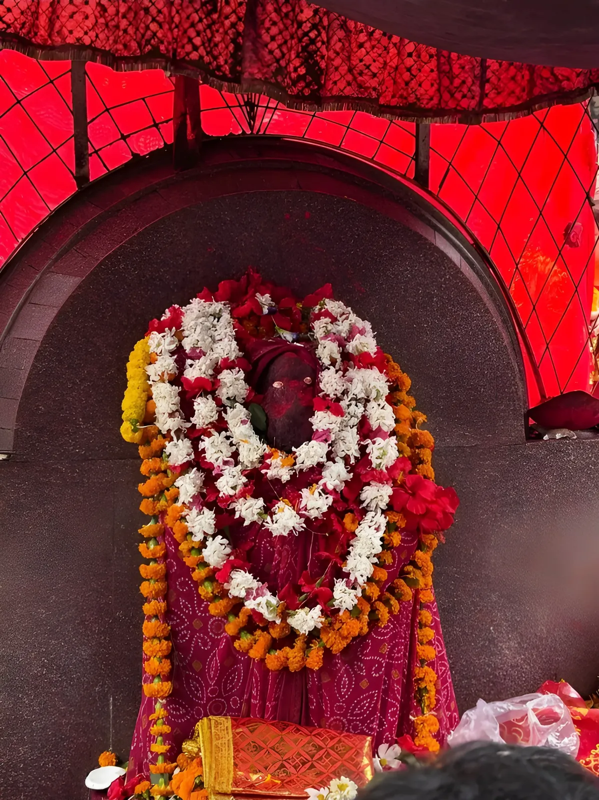 Sacred Kamakhya Temple shrine adorned with colorful flower garlands and offerings