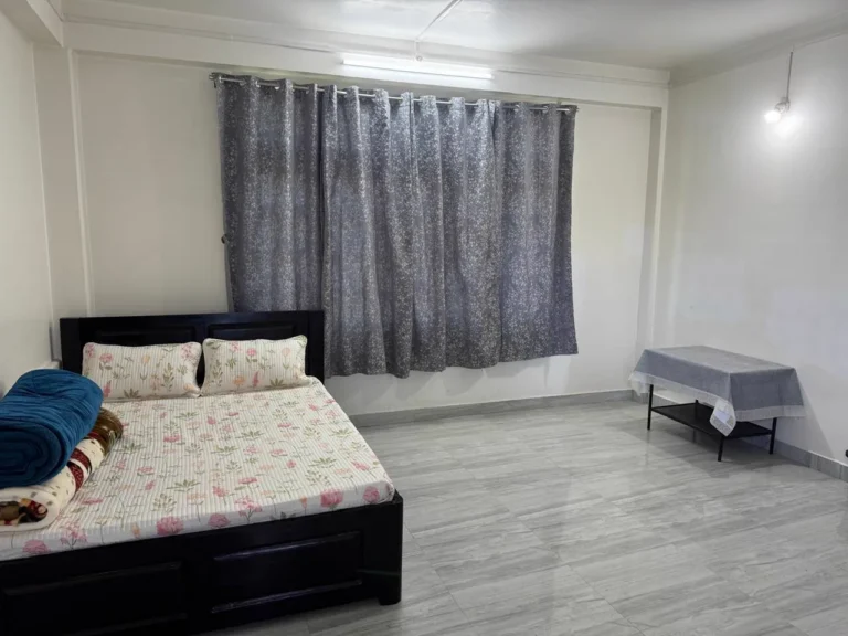 Bedroom with double bed and curtains at Nirvana Homestay