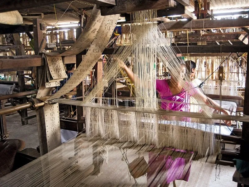 Weaving with traditional bamboo handloom at sualkuchi village